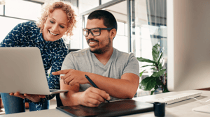 Two people happily looking at screen