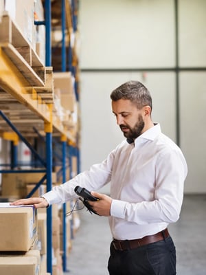Man-Using-Handheld-In-Warehouse