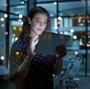 Woman-Looking-At-Tablet-with-Bokeh