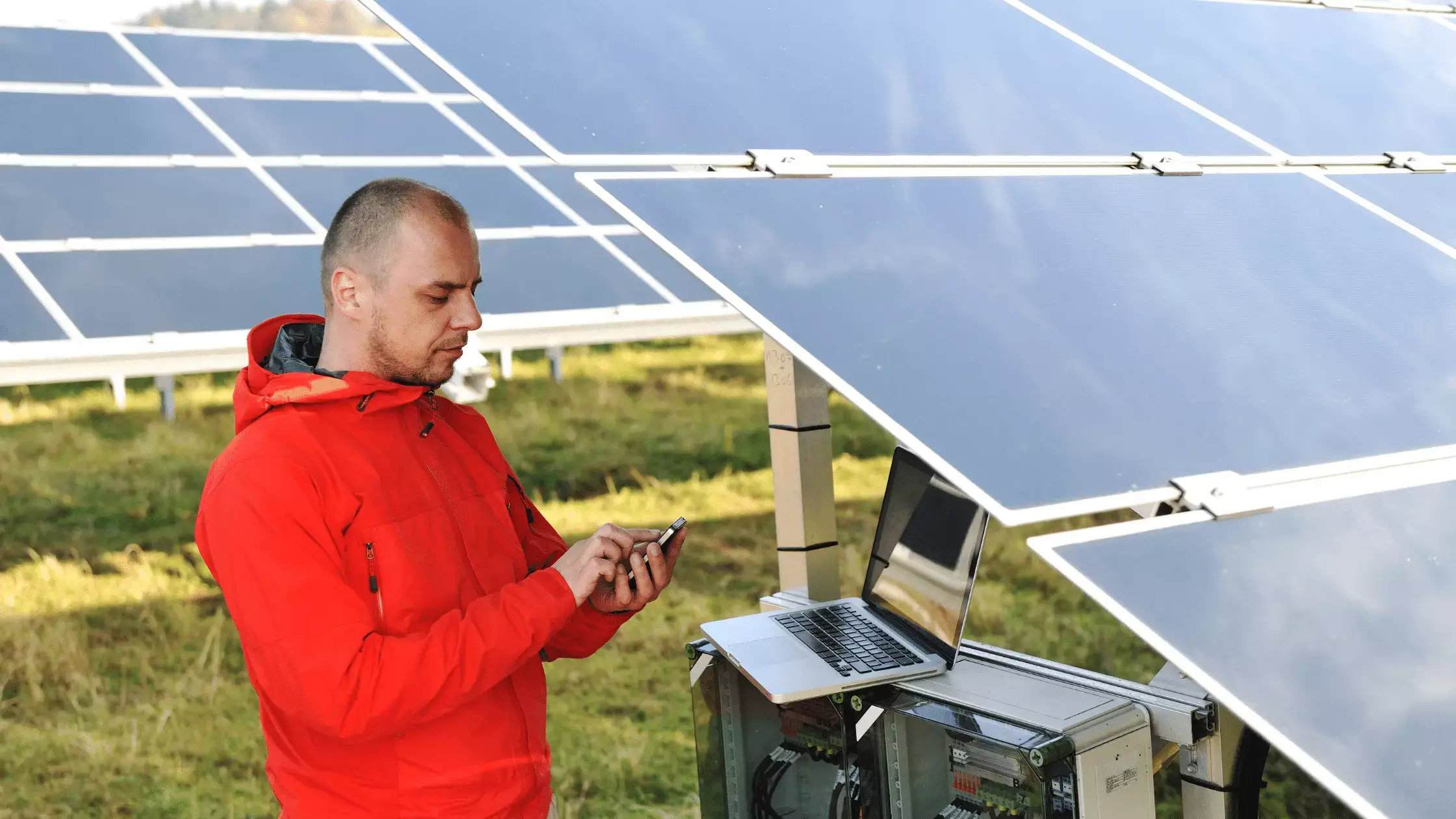 business man engineer using laptop at solar panels plant eco energy field in background